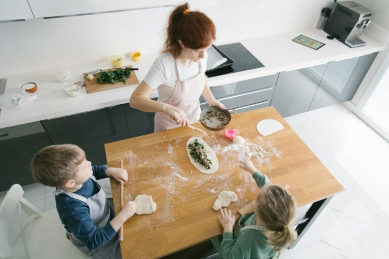 A woman and two kids prepare dough and filling in a modern kitchen.