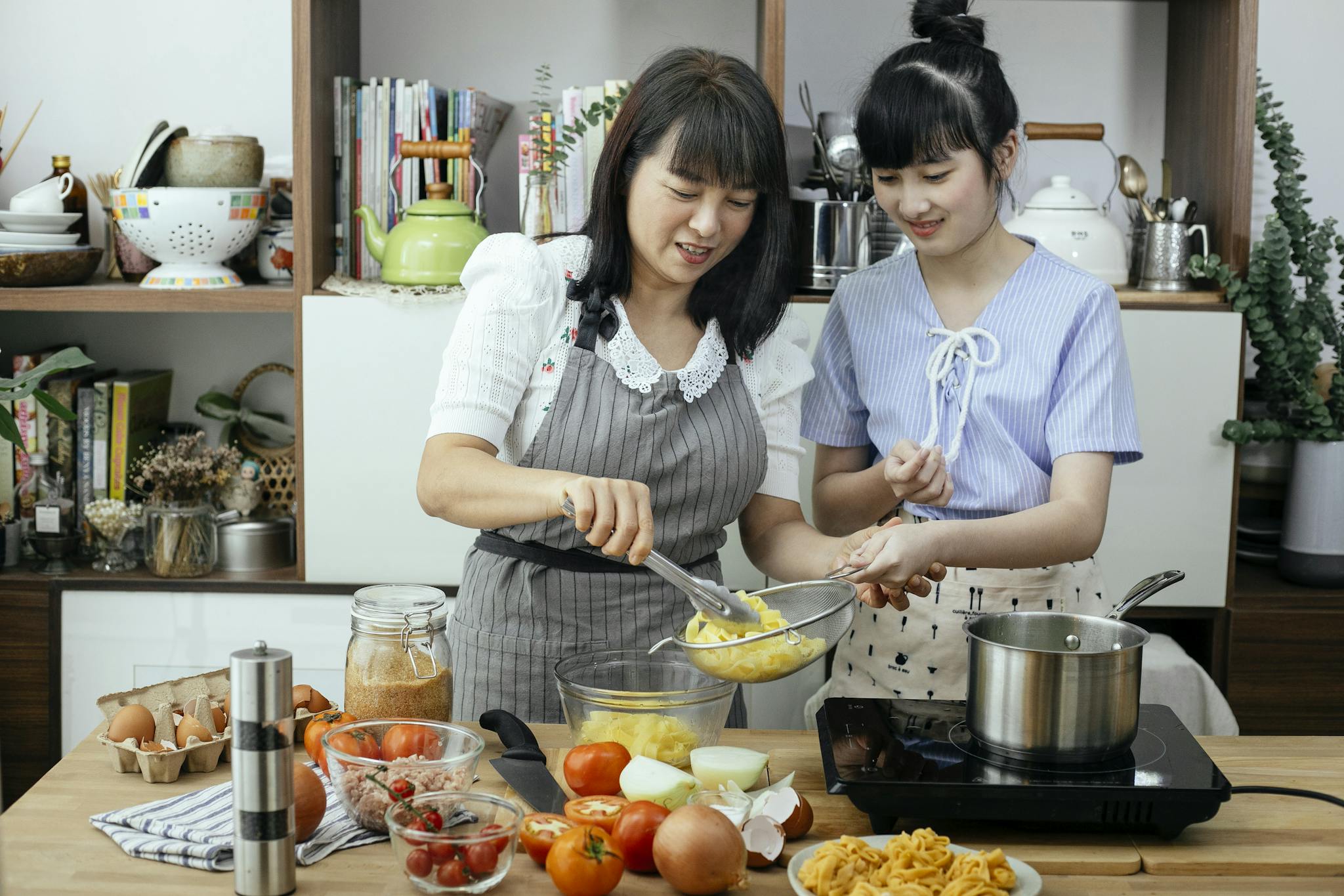 Mother and daughter preparing a healthy homemade meal in a cozy kitchen setting.